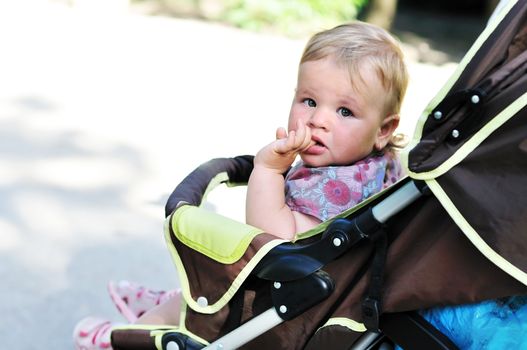 baby girl in the pram licking finger