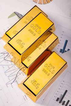 Gold bars with a linear graph, ambient financial concept