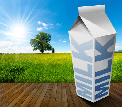White packaging of fresh milk with text Milk, in a countryside landscape with green grass and a tree on blue sky with clouds and sun rays
