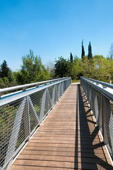 Beautiful  metal bridge to the boardwalk over the creek in the park