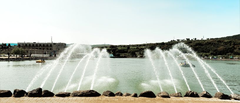 Fountains spurting into the lake and were sprayed people boating