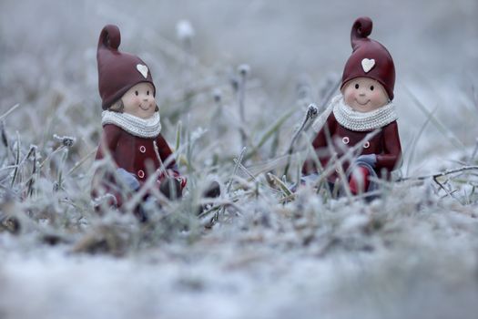 Two christmas figures in the frosty grass