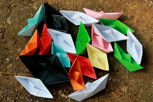 Colorful paper boats on barren land