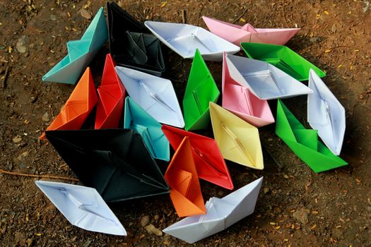 Colorful paper boats on barren land