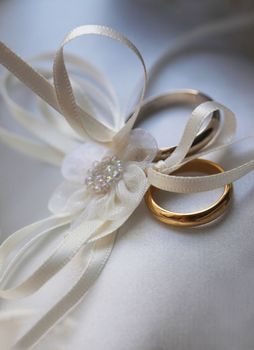 Wedding rings on a white satiny fabric