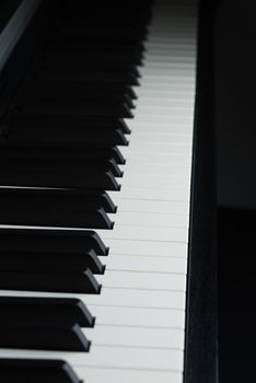 A dramatically dark picture of a piano's keyboard.