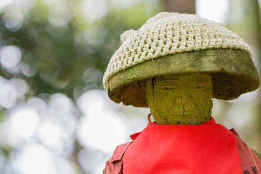 A Jizo statue (bodhisattva who looks over children, travellers and the underworld) with a red apron.