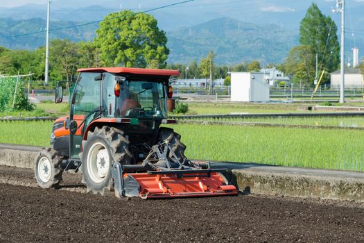 A tractor tilling a rice field in the countryside of Kochi, Japan.