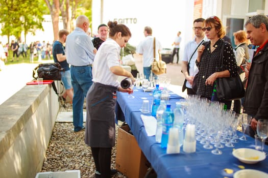 VENICE, ITALY - MAY 06: Waiter pours a drink during the vernissage of the 56th Venice Biennale on May 06, 2015