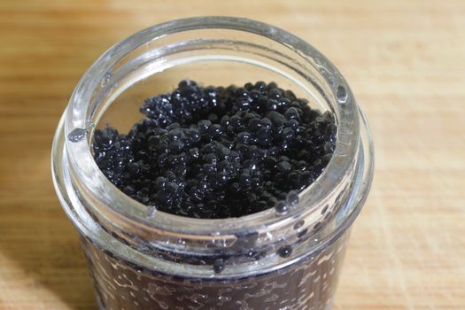 Black caviar in glass bank close-up