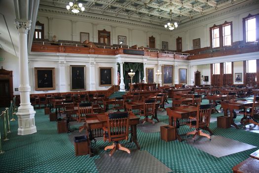 Desks and chairs in the historic senate chamber located in the Texas Capitol building.