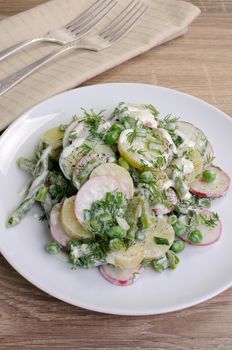 Potato salad with radishes, peas, beans in yogurt dressing