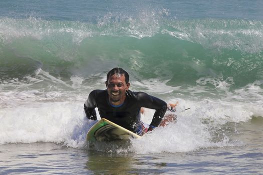 Young men - the surfer in ocean. Bali. Indonesia