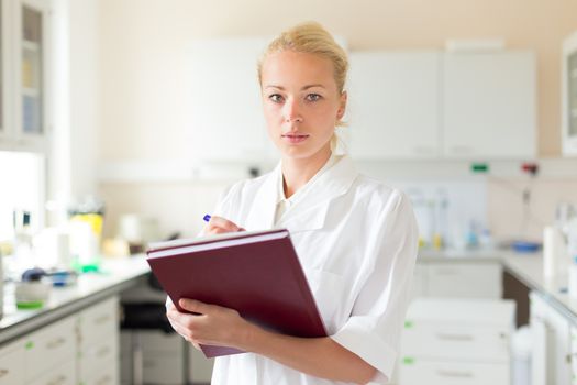 Portrait of an attractive, young, confident female health care professional in his working environment.