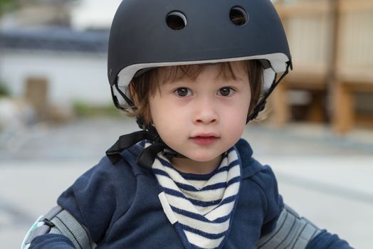 A cute young boy with a black bicycle helmet