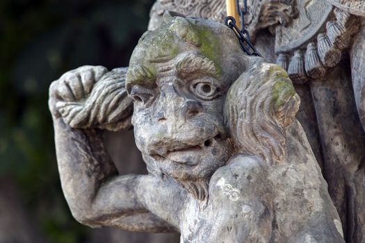 Baroque statue on the crossroad - Saint Procopius with bound devil.
Saint Procopius of Sazava (end of the 10th century Chotoun - March 25, 1053, Sazava) was originally a secular priest, later a hermit, co-founder and first abbot of the monastery Sazava. He was canonized in 1204. 
His main attribute is bound devil, which is at his feet or on which he stands.
Czech republic.