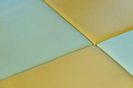 A close up of green and yellow soft mats in a kids play area.