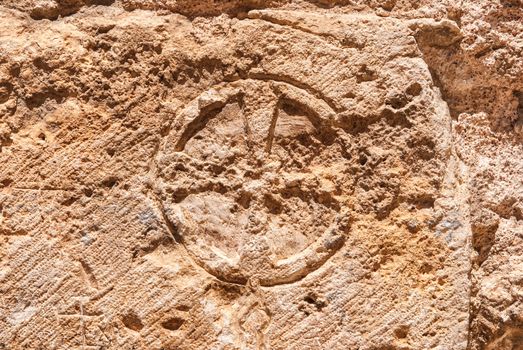 Christian cross of stone  wall of the Church of the Holy Sepulchre in the Old City of Jerusalem.