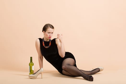 Studio portrait of a beautiful young brunette woman holding a glass of white wine