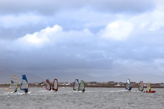 wind surfers racing in the storm winds on the wild atlantic way in county Kerry Ireland