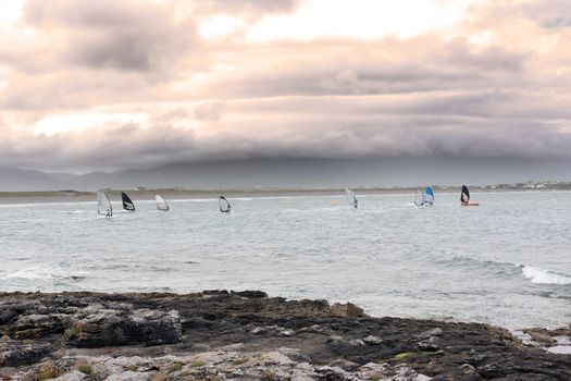 wind surfers racing in the storm winds on the wild atlantic way in county Kerry Ireland