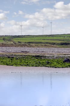 reflections on beal beach co kerry ireland on a cold winters morning with turbines in the background