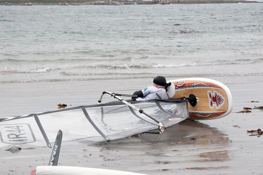 windsurfer having a nap on the beach in the maharees county kerry ireland