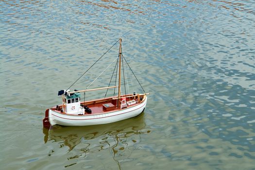 Sailing remote control model scale sail boat in a small lake                               