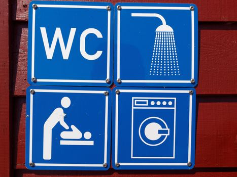 Blue sign of public toilets WC shower washing machines baby changing in a camping site