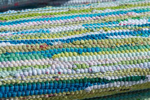Close up colorful hand made rug carpet in blue, green and white                               