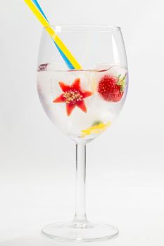 frozen fruit and flower in glass with straws