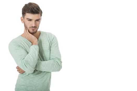 Puzzled handsome young man scratching his head with his hand as he looks at the camera with an uncertain perturbed expression, isolated on white