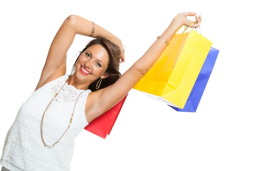 Very Happy Stylish Woman Raising Three Colored Shopping Paper Bag with Mouth Open and Looking at the Camera. Isolated on White Background.