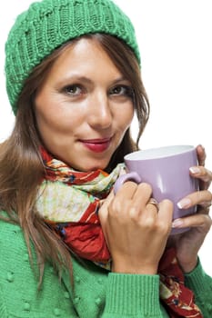 Close up Pretty Young Woman Wearing Green and Red Winter Fashion, Holding a Cup of Coffee While Smiling at the Camera. Isolated on White Background.