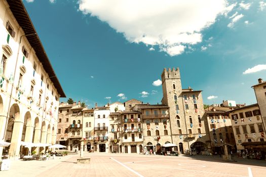 AREZZO, ITALY - MAY 12, 2015: Tourists enjoy Piazza Grande on a beautiful day. Arezzo is a very famous tuscan medieval city.