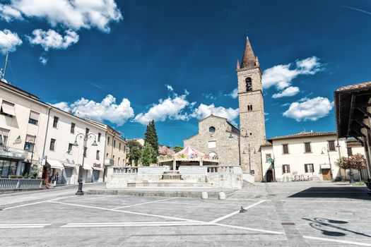 AREZZO, ITALY - MAY 12, 2015: People walk in Saint Augustin Square. Arezzo is one of the most famous tuscan medieval cities.
