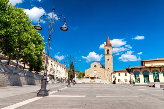 AREZZO, ITALY - MAY 12, 2015: People walk in Saint Augustin Square. Arezzo is one of the most famous tuscan medieval cities.