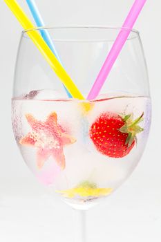 frozen fruit and flower in glass with straws