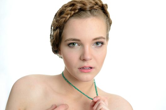 Portrait of girl with necklace made of emeralds. Female model holds precious stones with her hand.