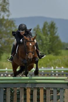 An horsewoman of obstacle in competition