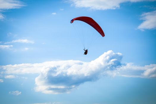 Paragliders flying over green fields with typical romanian village on background