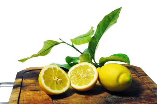 lemons with leaves on a cutting board ready to be cooked