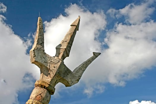 A stone trident with sky and clouds