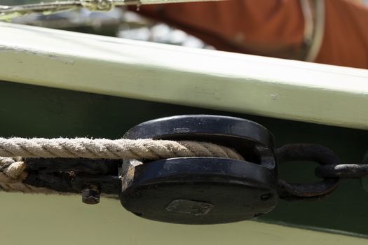 A close up on a block with a rope on a boat