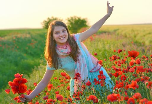 Young beautiful girl in poppy field