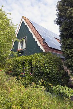 traditional dutch house with wooden front and solar panels in summer