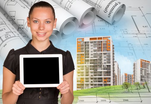 Smiling young woman holding tablet and looking at camera on abstract background with buildings and graphs