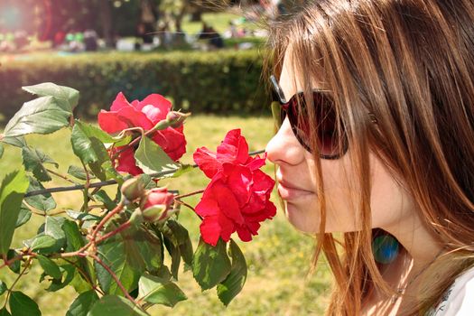 girl smell red roses in garden