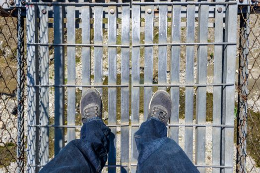Looking down on a suspension bridge over a river in Nepal