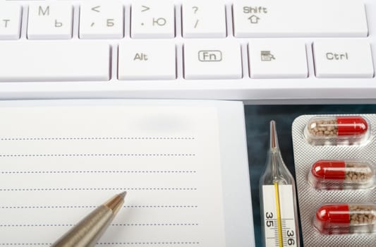 X-ray examination, notebook and keyboard with thermometer, drugs, close up view